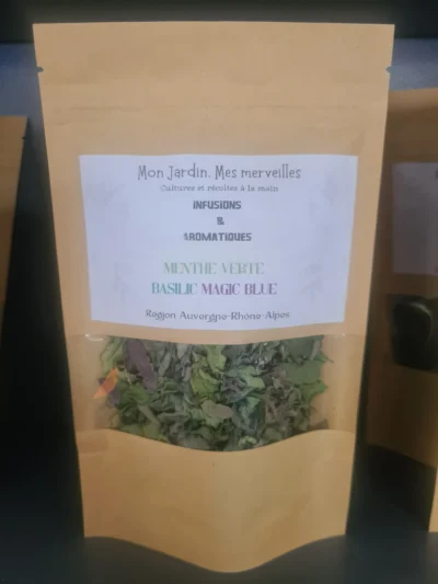 Sachet en papier kraft avec une fenêtre transparente laissant apparaître les feuilles sèches de basilic magic blue et menthe verte