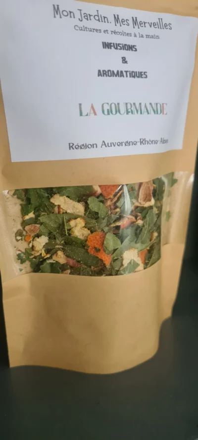 Sachet de tisane vue de profil en papier kraft avec une fenêtre transparente laissant apparaitre les plantes sèches gourmandes